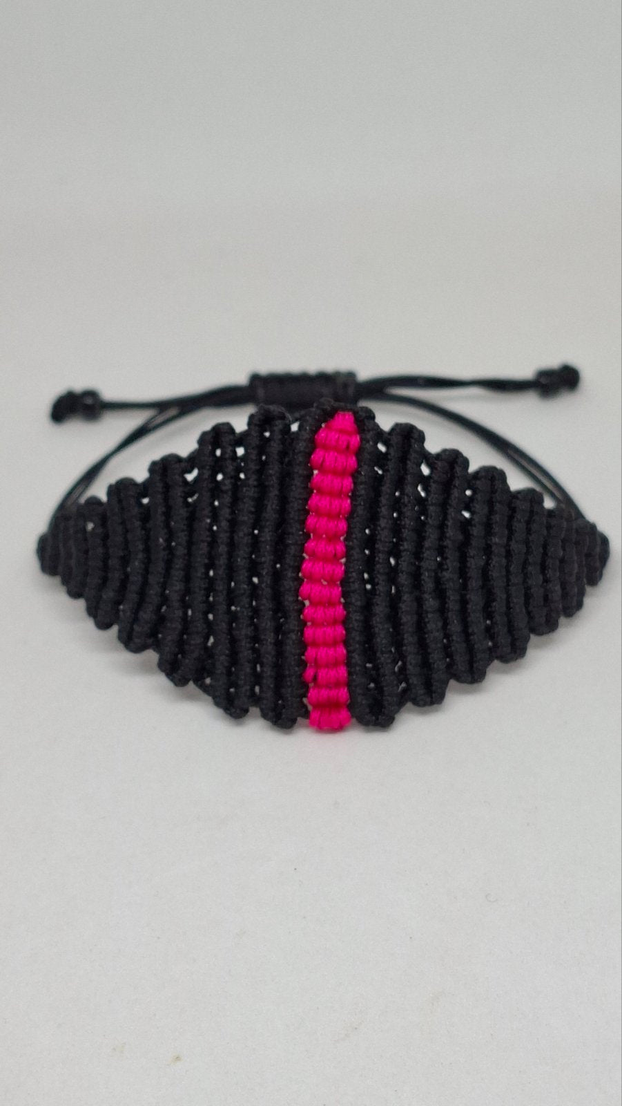 Handmade black macramé bracelet with pink accent stripe - back view