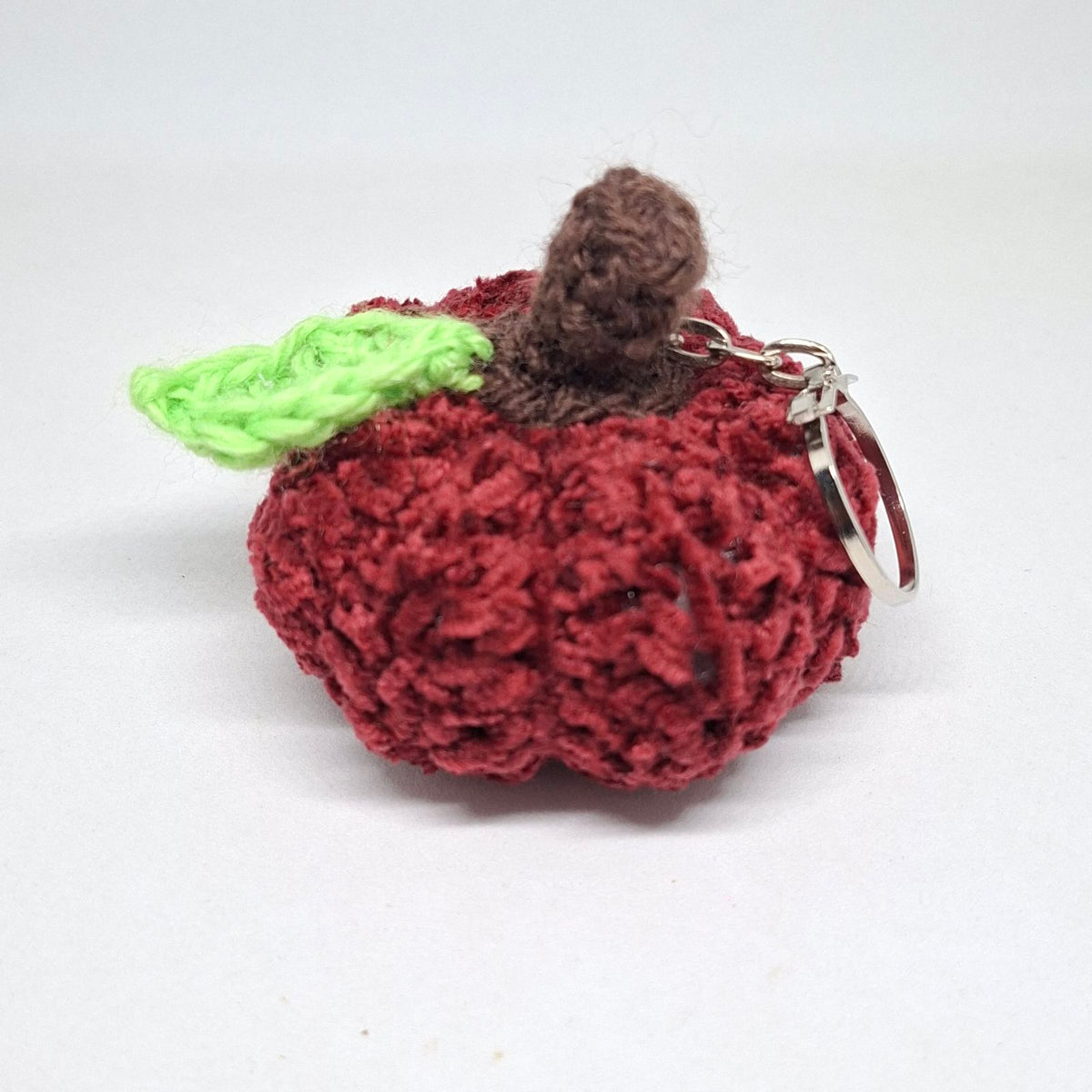 Burgundy crochet pumpkin keyring with green leaf and brown stalk