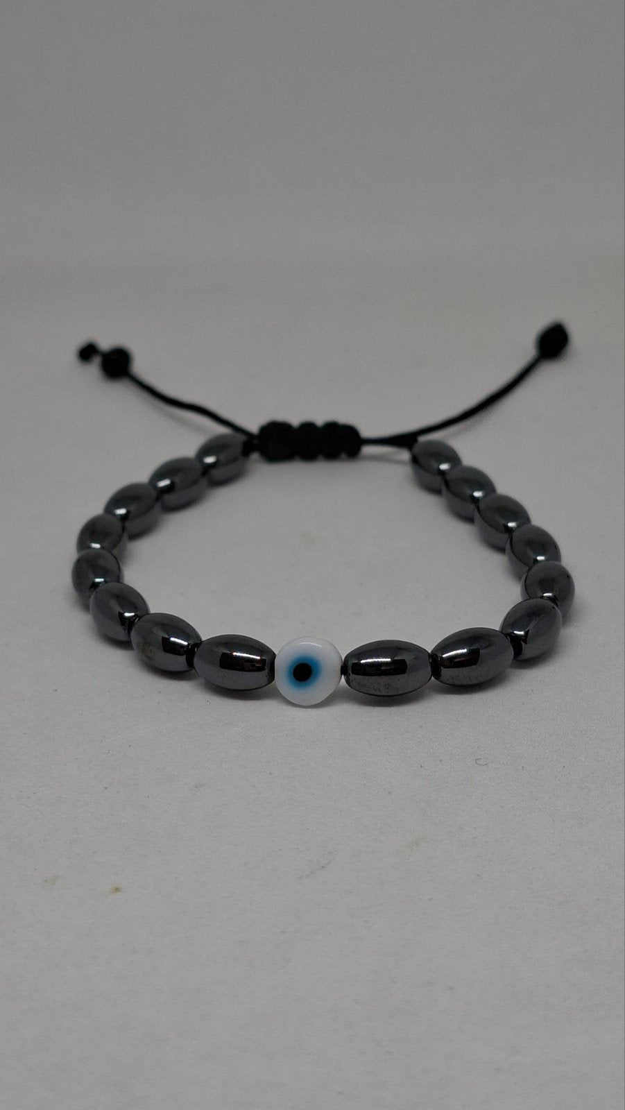 Hematite evil eye bracelet on a white background