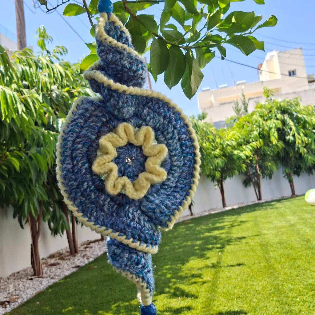 Close-up of handmade crochet evil eye spiral garden hanging outdoors – Georgia Create Cyprus