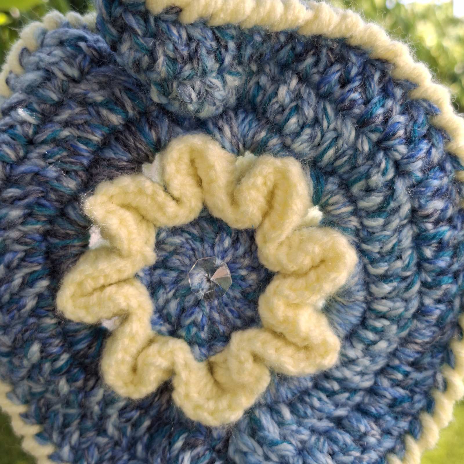 Detail of cream flower centre with crystal bead on handmade crochet garden hanging – Georgia Create