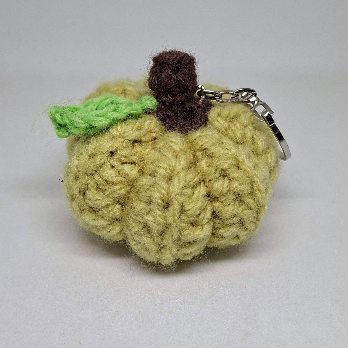 Pale green crochet pumpkin keyring with green leaf and brown stalk