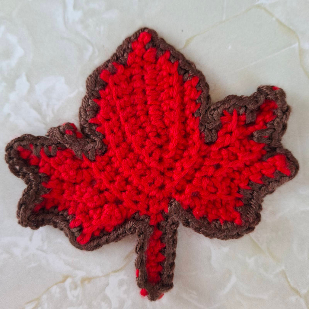 Red crochet leaf coaster with brown edging