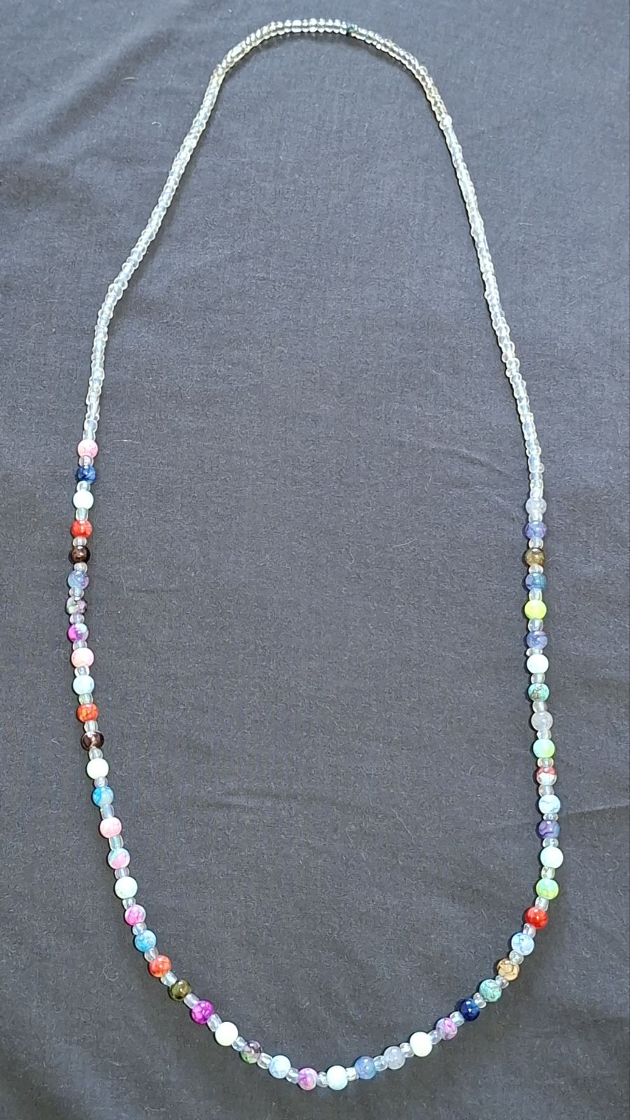 Multicolour beaded necklace laid flat on a dark background