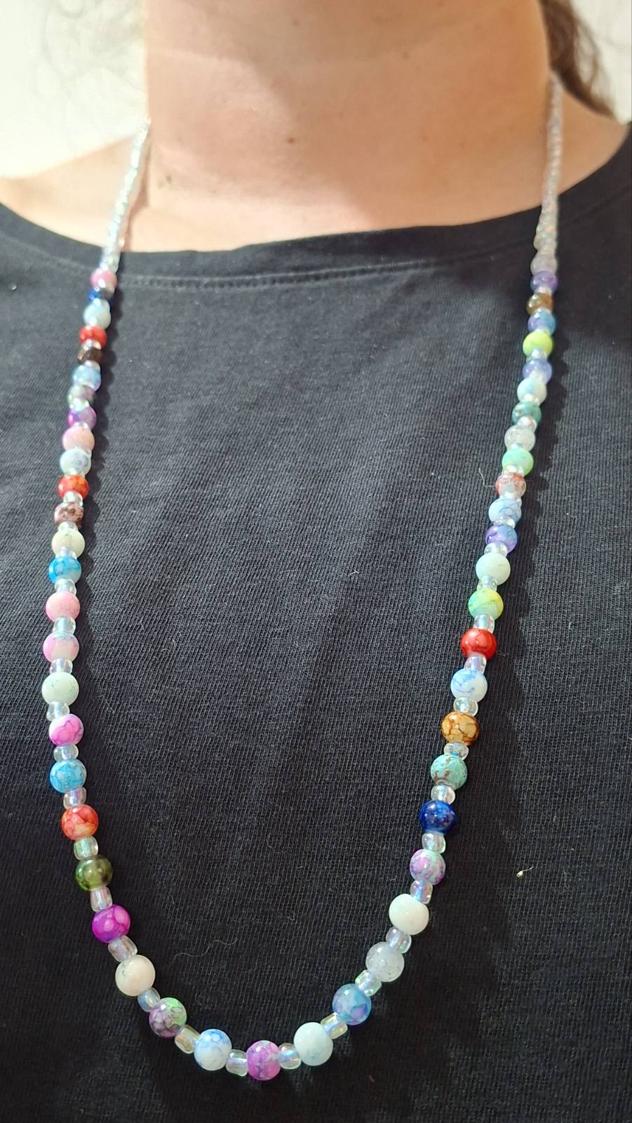 Multicolour beaded necklace worn over a black top