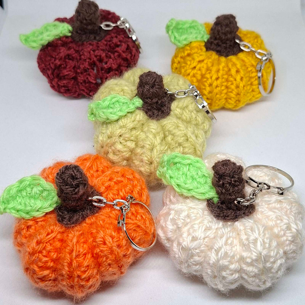 Crochet pumpkin keyrings in orange, cream, pale green, yellow and burgundy with green leaves and brown stalks