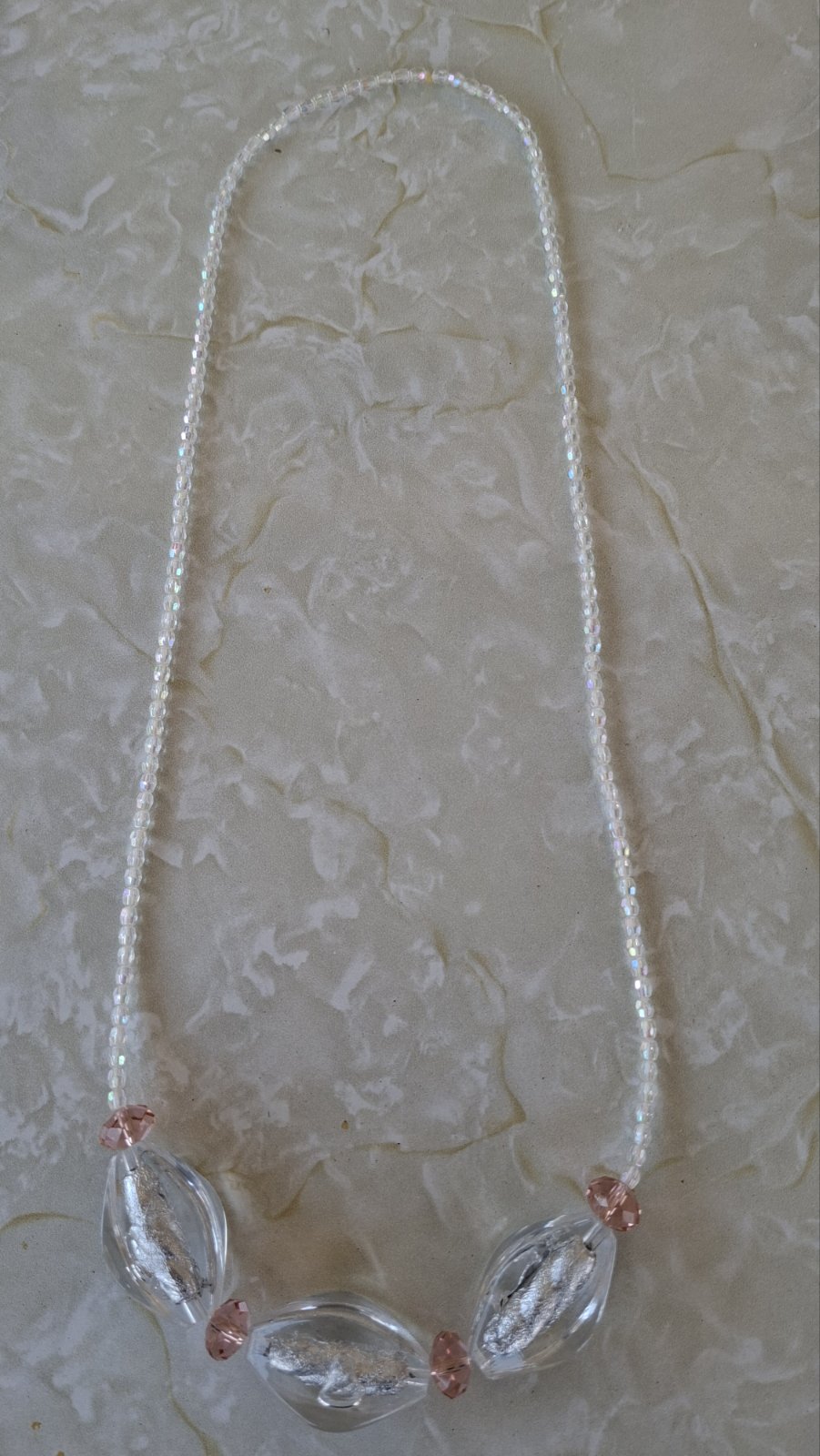 Full view of triple stone crystal necklace on white background